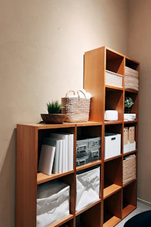 A bookshelf filled with lots of books next to a wall