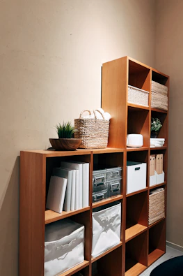 A bookshelf filled with lots of books next to a wall