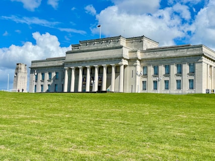 A large white building sitting on top of a lush green field