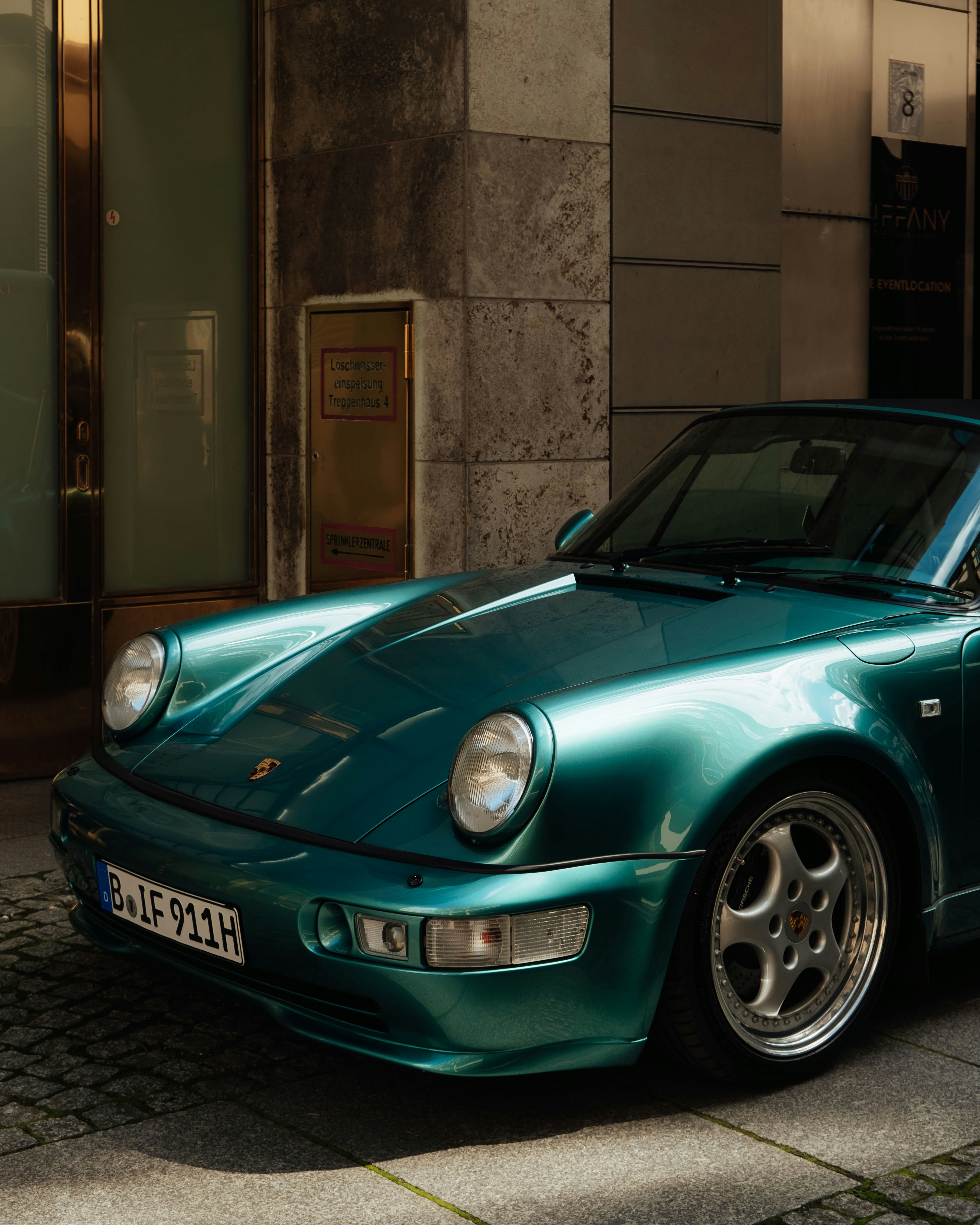 Ein grüner Sportwagen, der vor einem Gebäude parkt