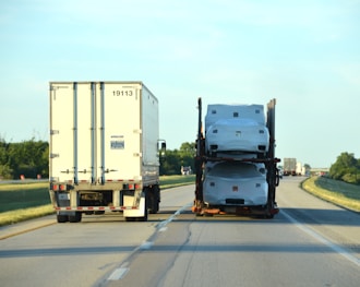 A couple of semi trucks driving down a highway
