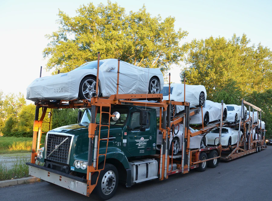 Sedan being driven up the ramp onto the upper deck of an open car carrier