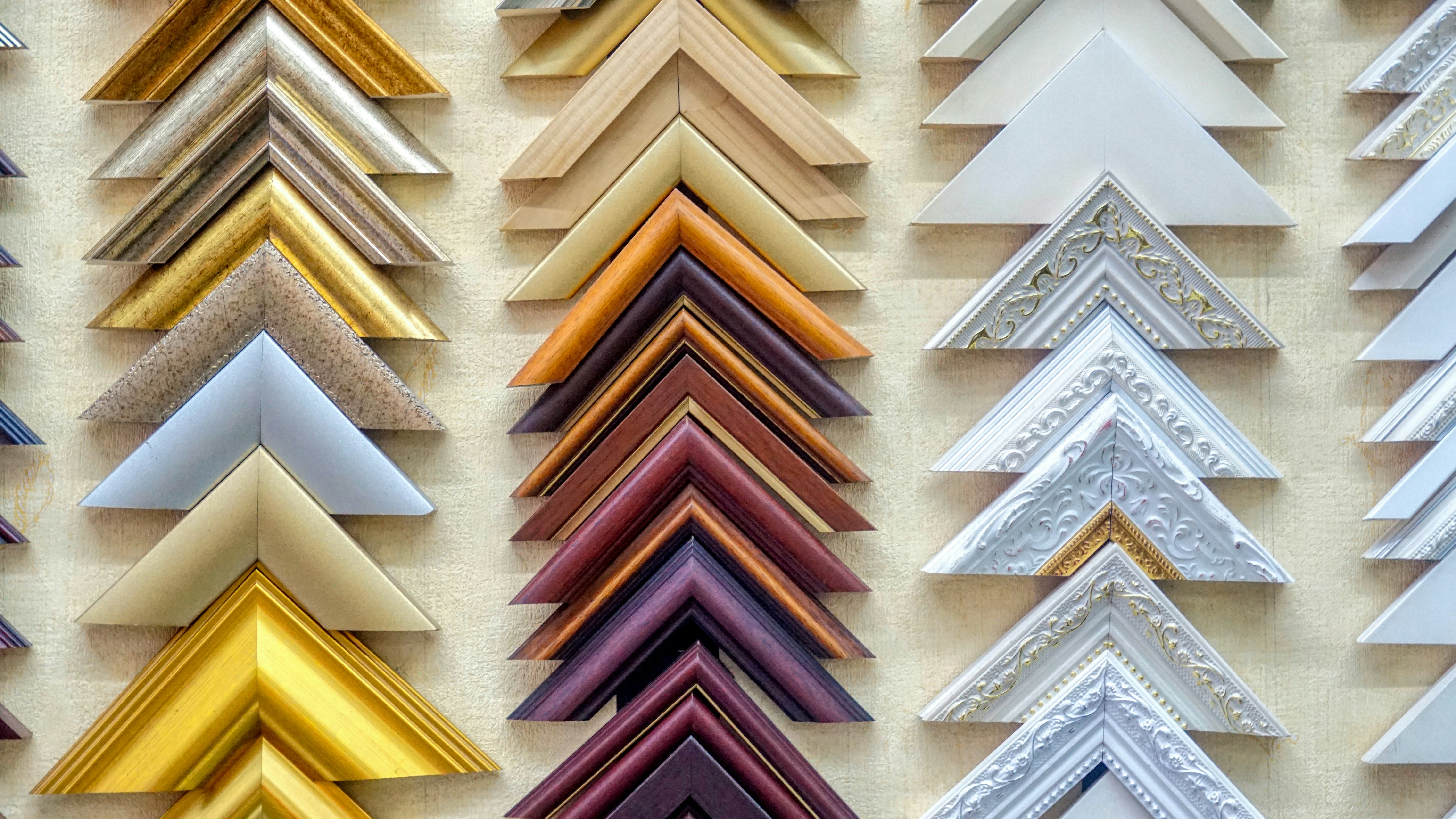 Rows of mitred moulding corner samples in gold, white, black and wine finishes