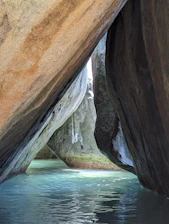 A man standing on a rock next to a body of water