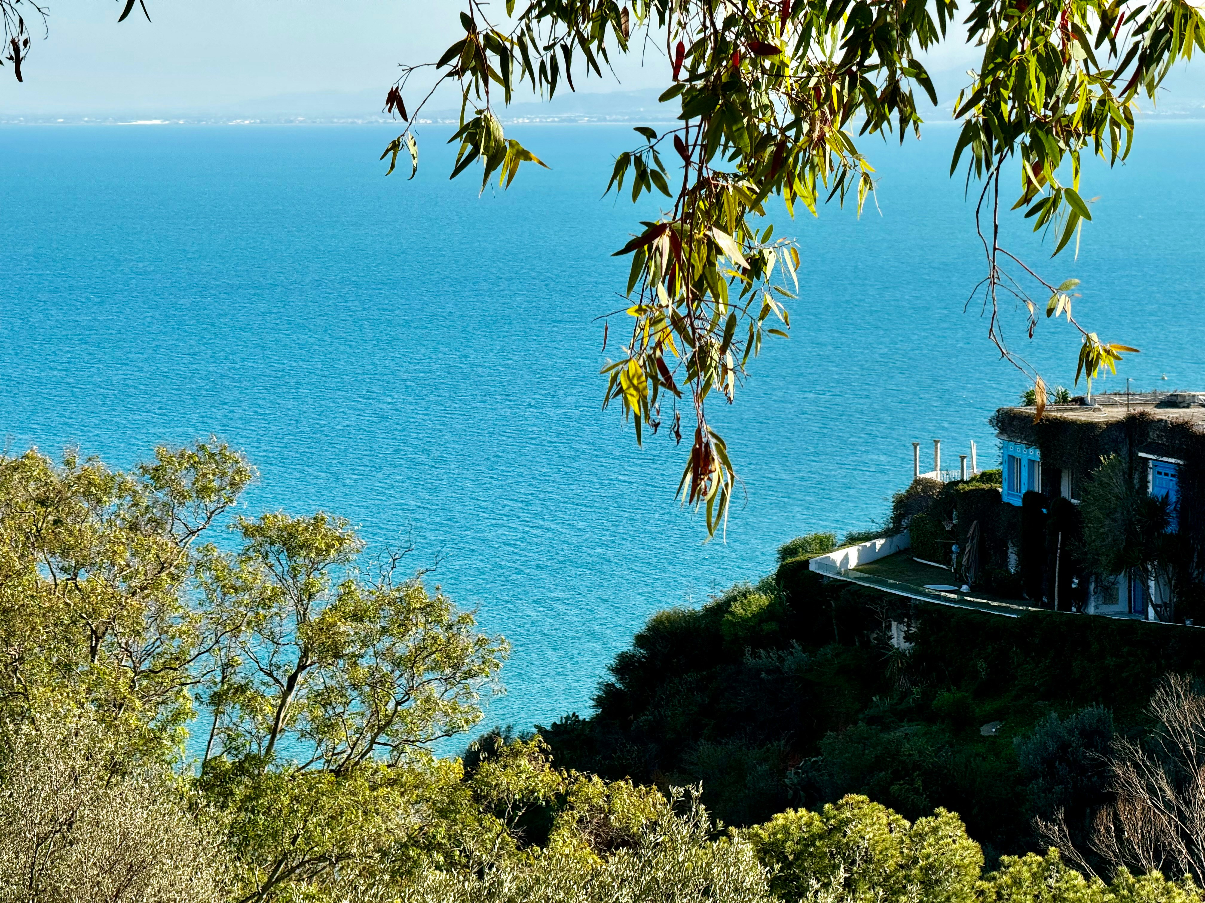 A house sitting on top of a hill next to the ocean