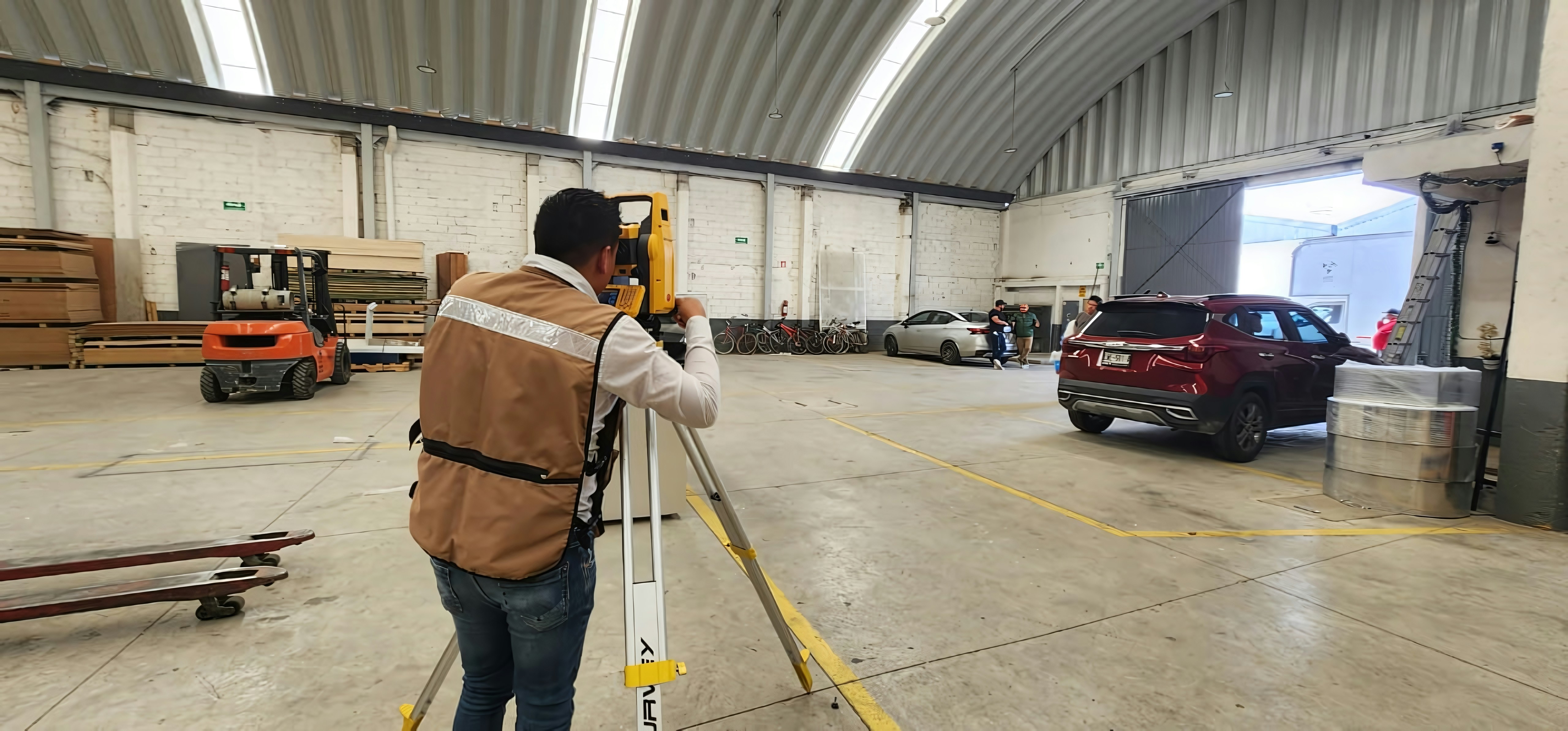 A man standing in a warehouse holding onto a rail