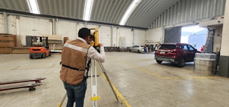 A man standing in a warehouse holding onto a rail