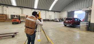 A man standing in a warehouse holding onto a rail