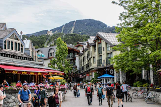 A group of people walking down a street next to tall buildings