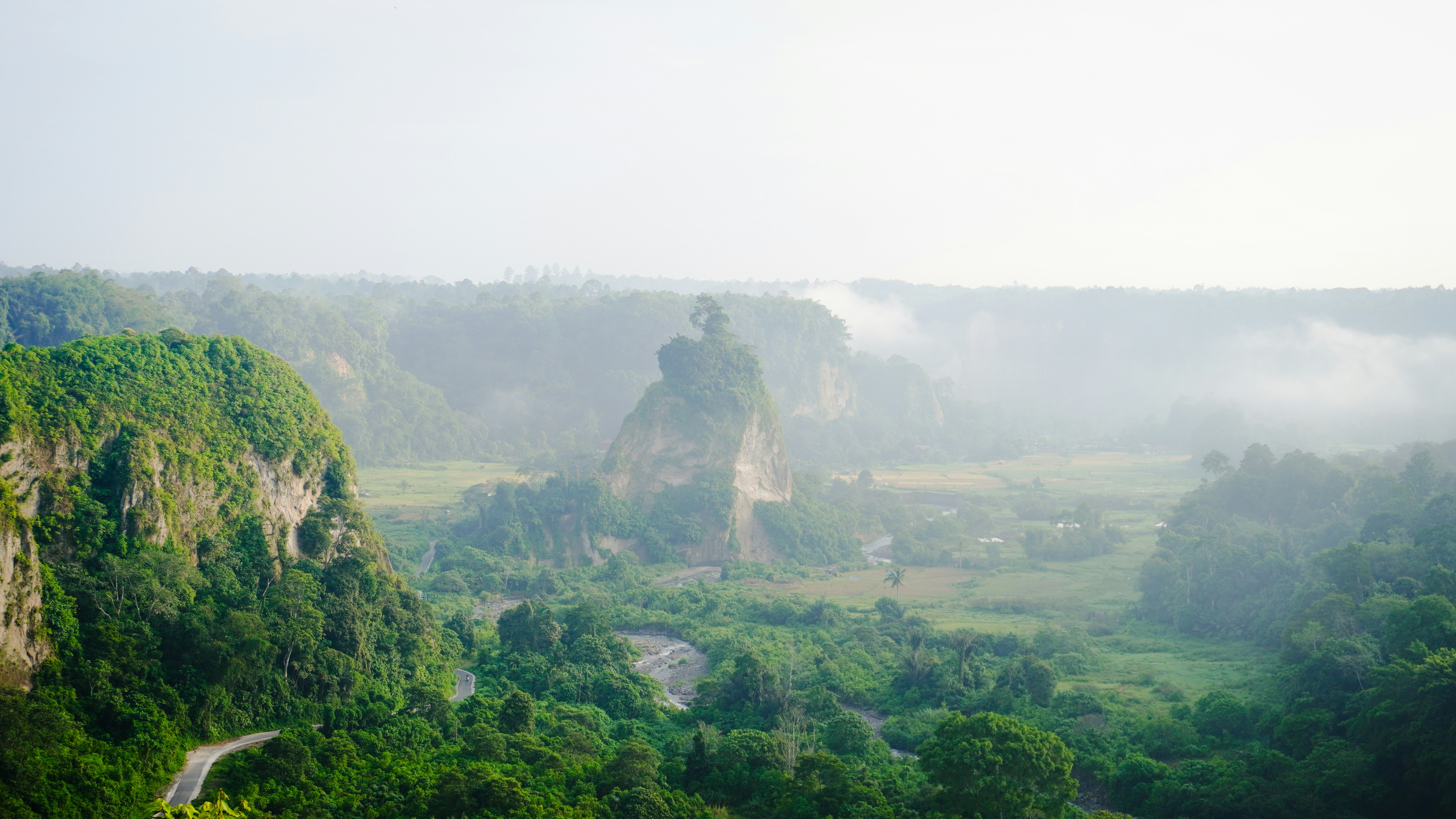 A view of a lush green valley surrounded by mountains