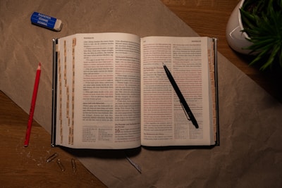 An open book on a table with a pen and pencil