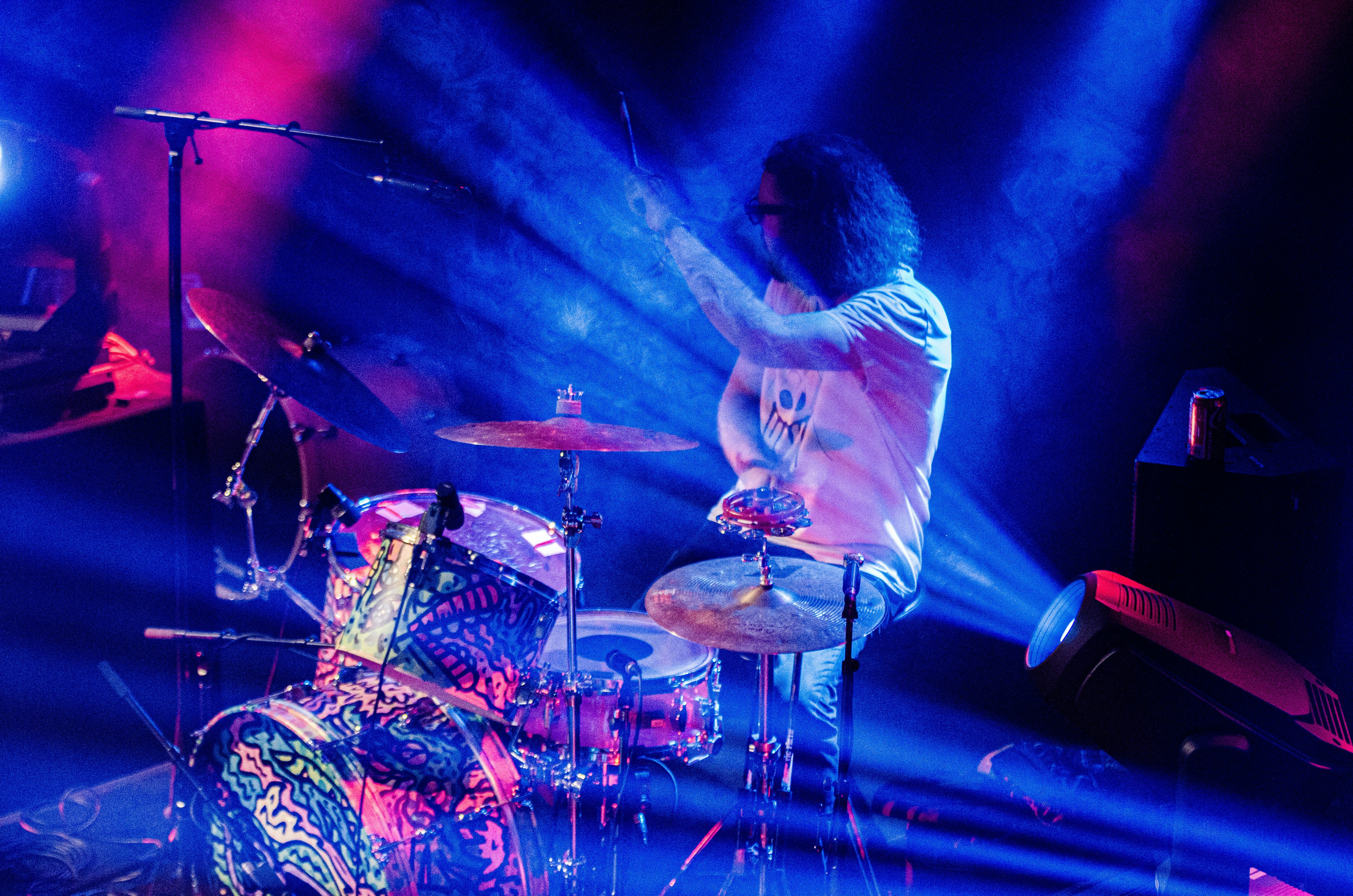A man is playing drums on stage at a concert