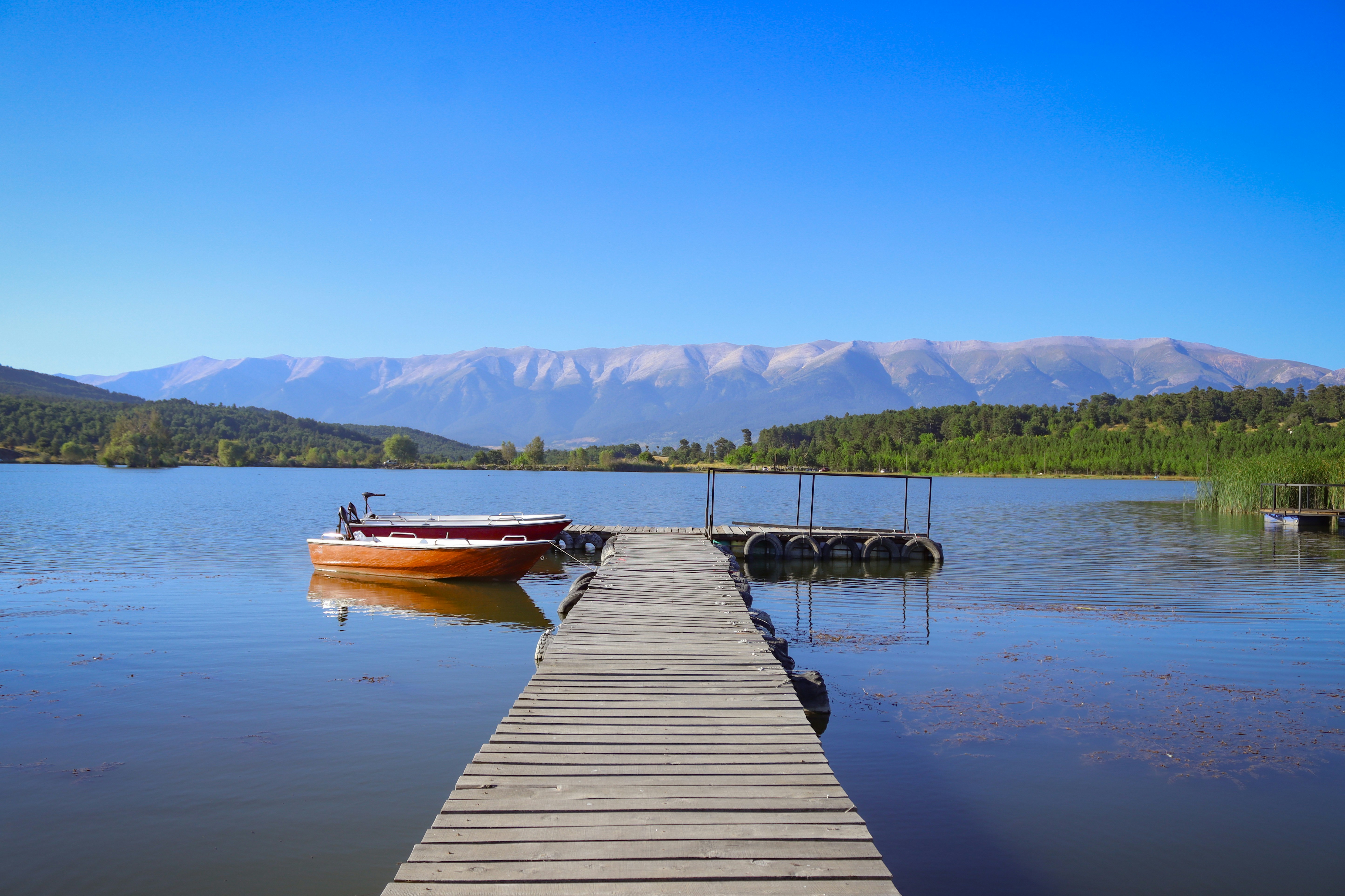 A boat is docked at the end of a pier
