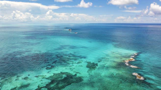 An aerial view of the ocean with boats in the water