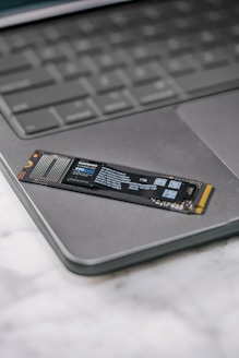 A close up of a laptop keyboard with a stick on it