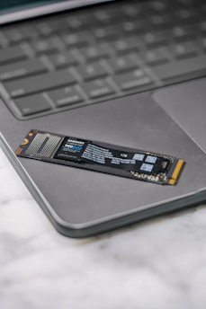 A close up of a laptop keyboard with a stick on it