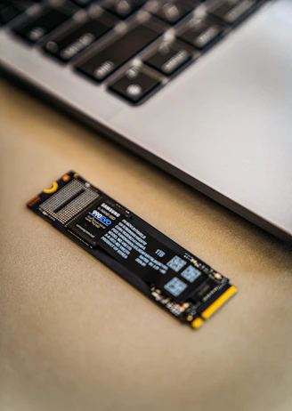 A close up of a laptop keyboard and a small piece of circuit board