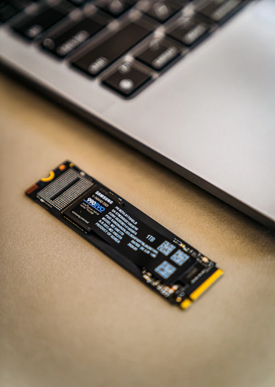 A close up of a laptop keyboard and a small piece of circuit board