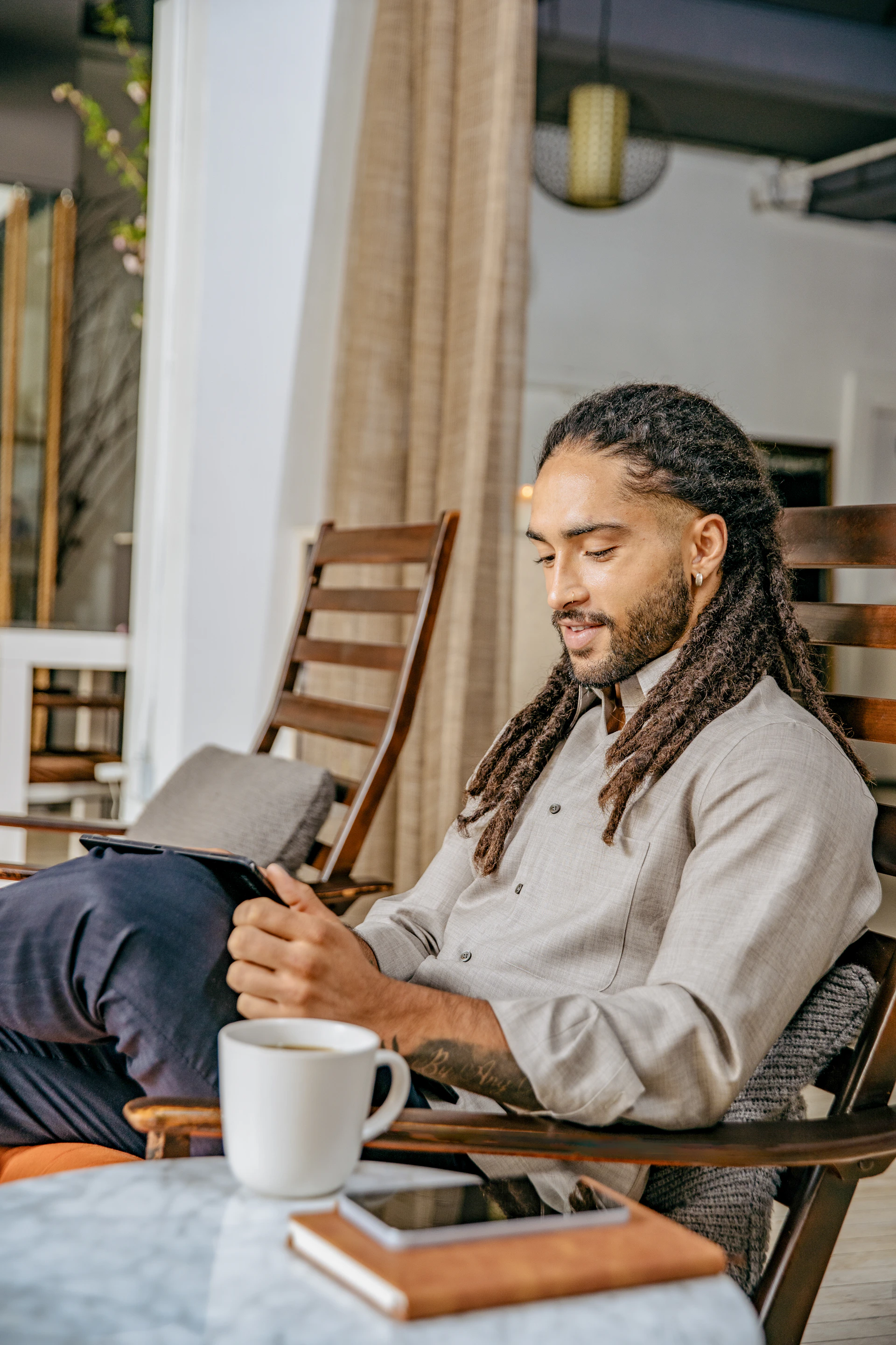 A man sitting at a table with a book and a cup of coffee