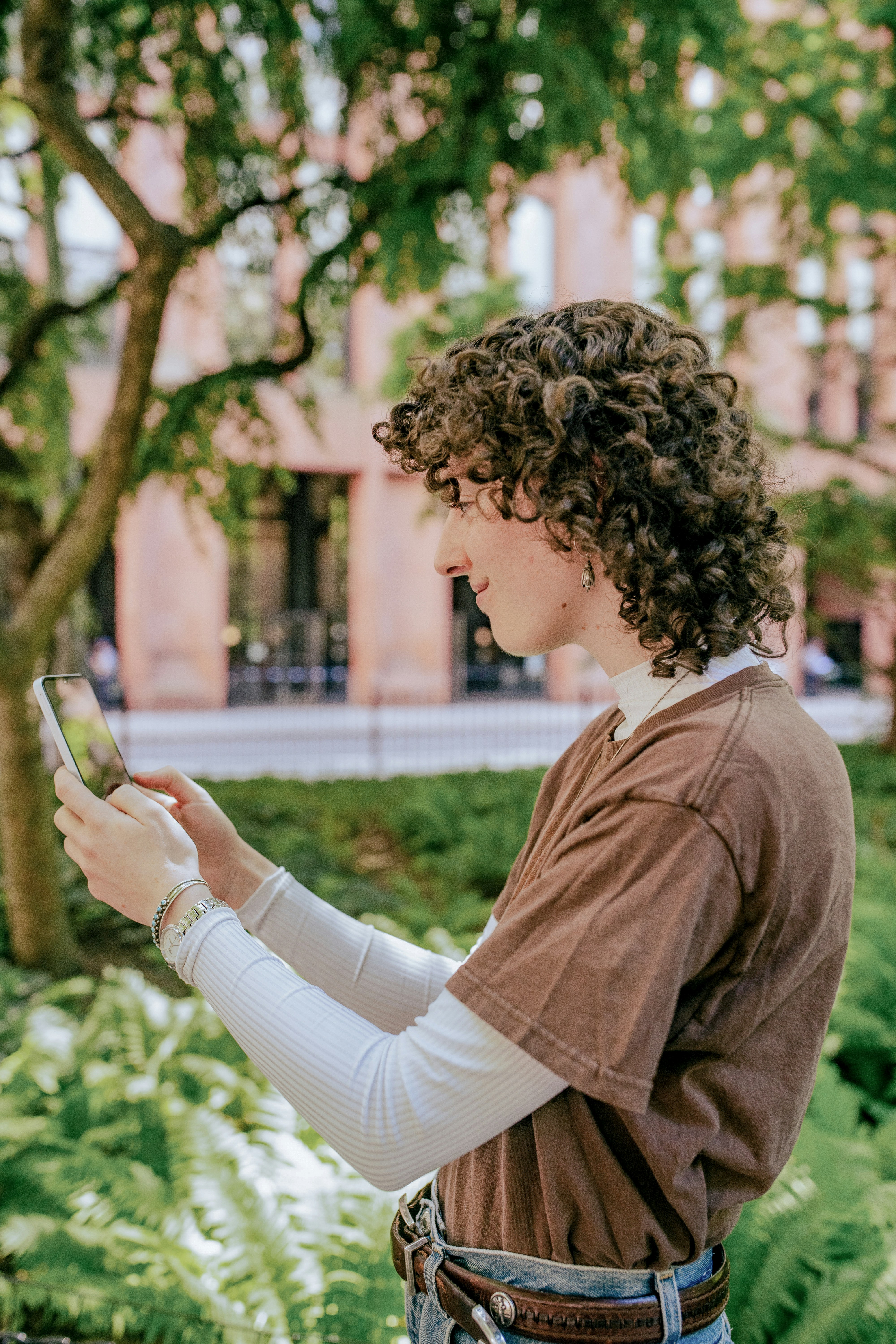 A woman standing in a park looking at her cell phone