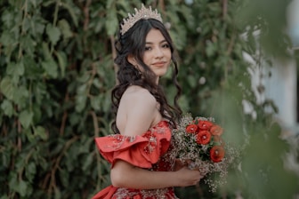 A woman in a red dress holding a bouquet of flowers