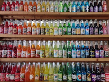 A wooden shelf filled with lots of bottles
