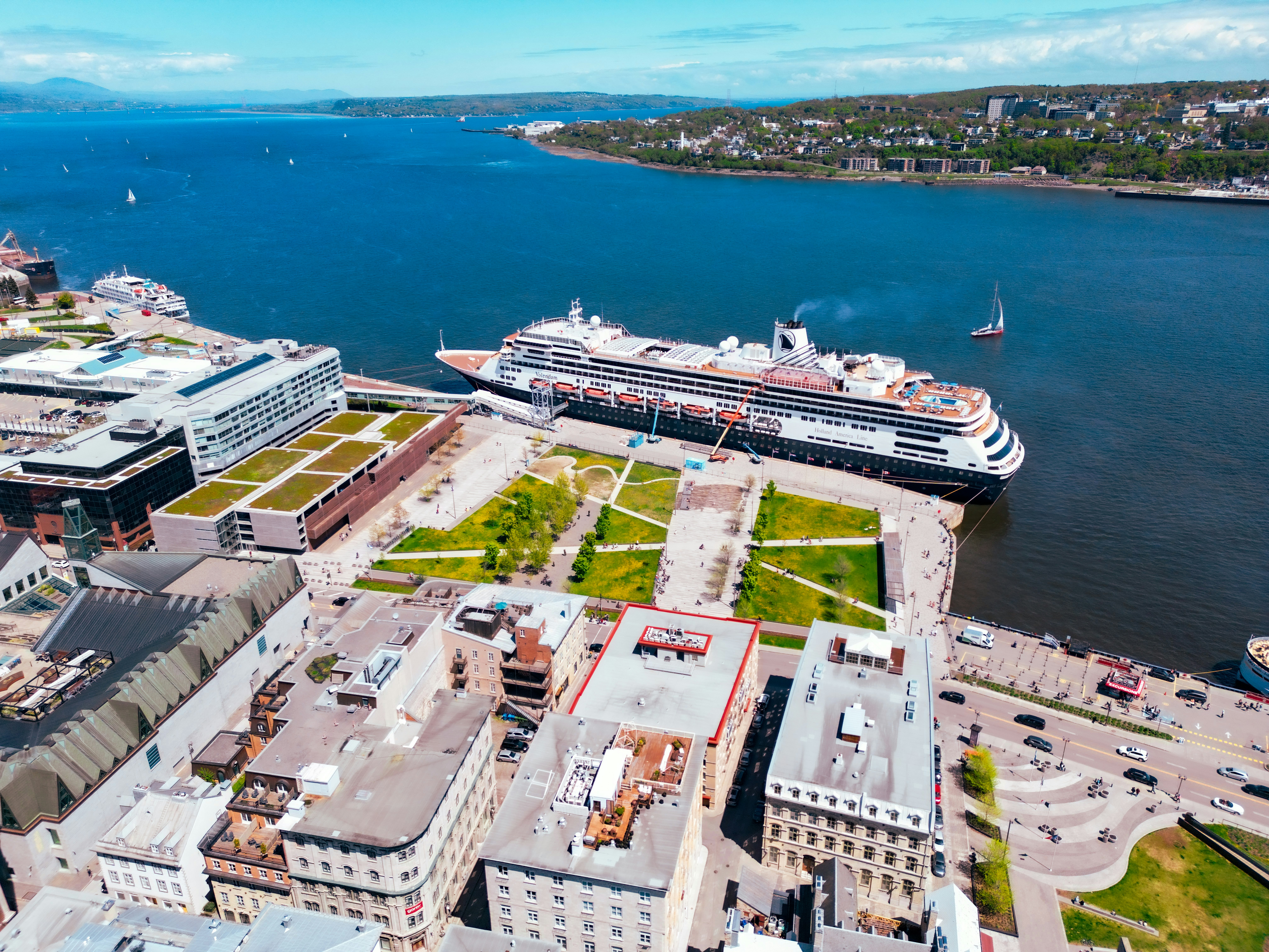 An aerial view of a city with a cruise ship in the background