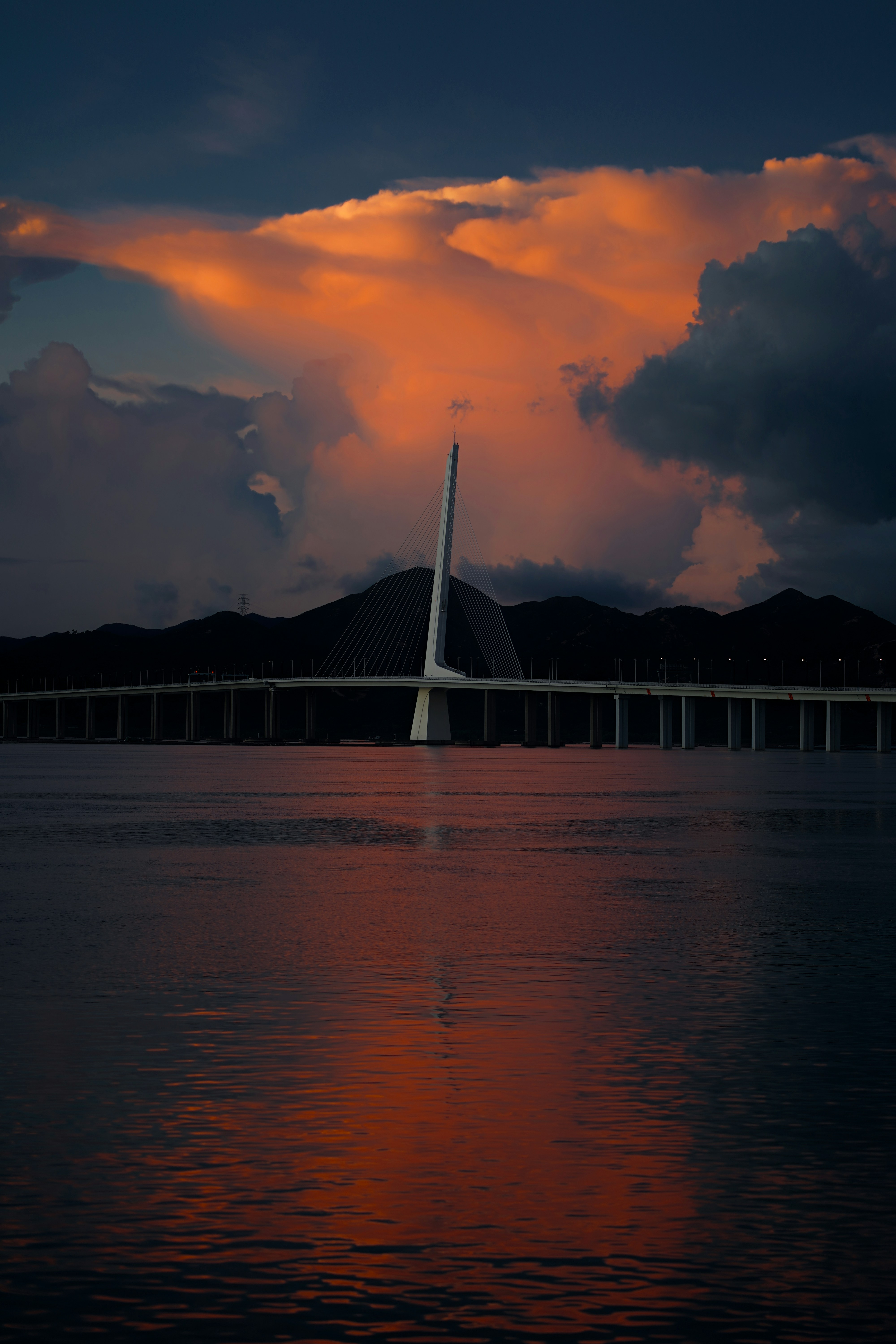 A large bridge over a body of water under a cloudy sky photo – Free ...