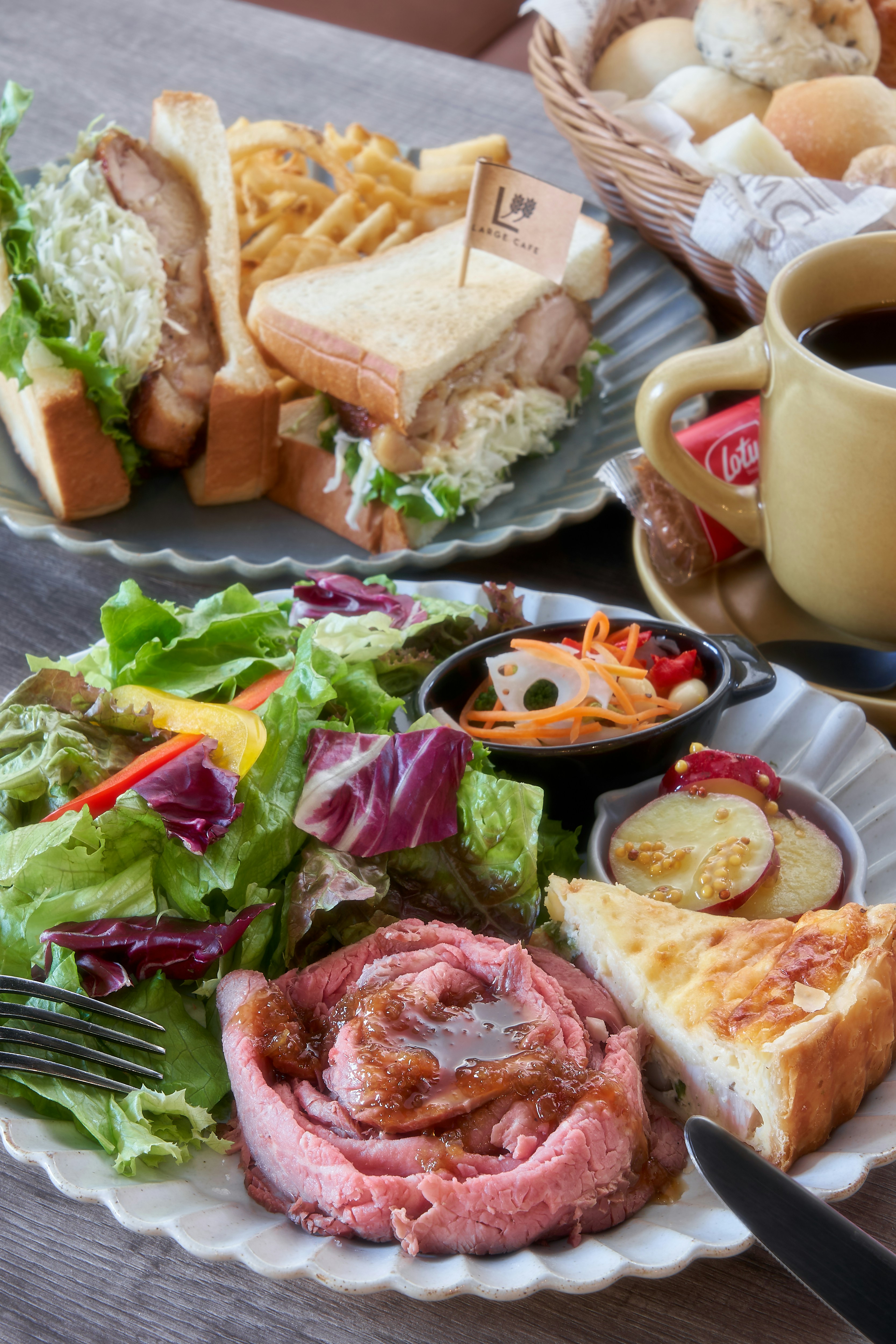 Assorted cafe dishes and coffee spread across a wooden table.
