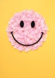 A smiley face made out of flowers on a yellow background