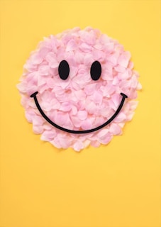 A smiley face made out of flowers on a yellow background