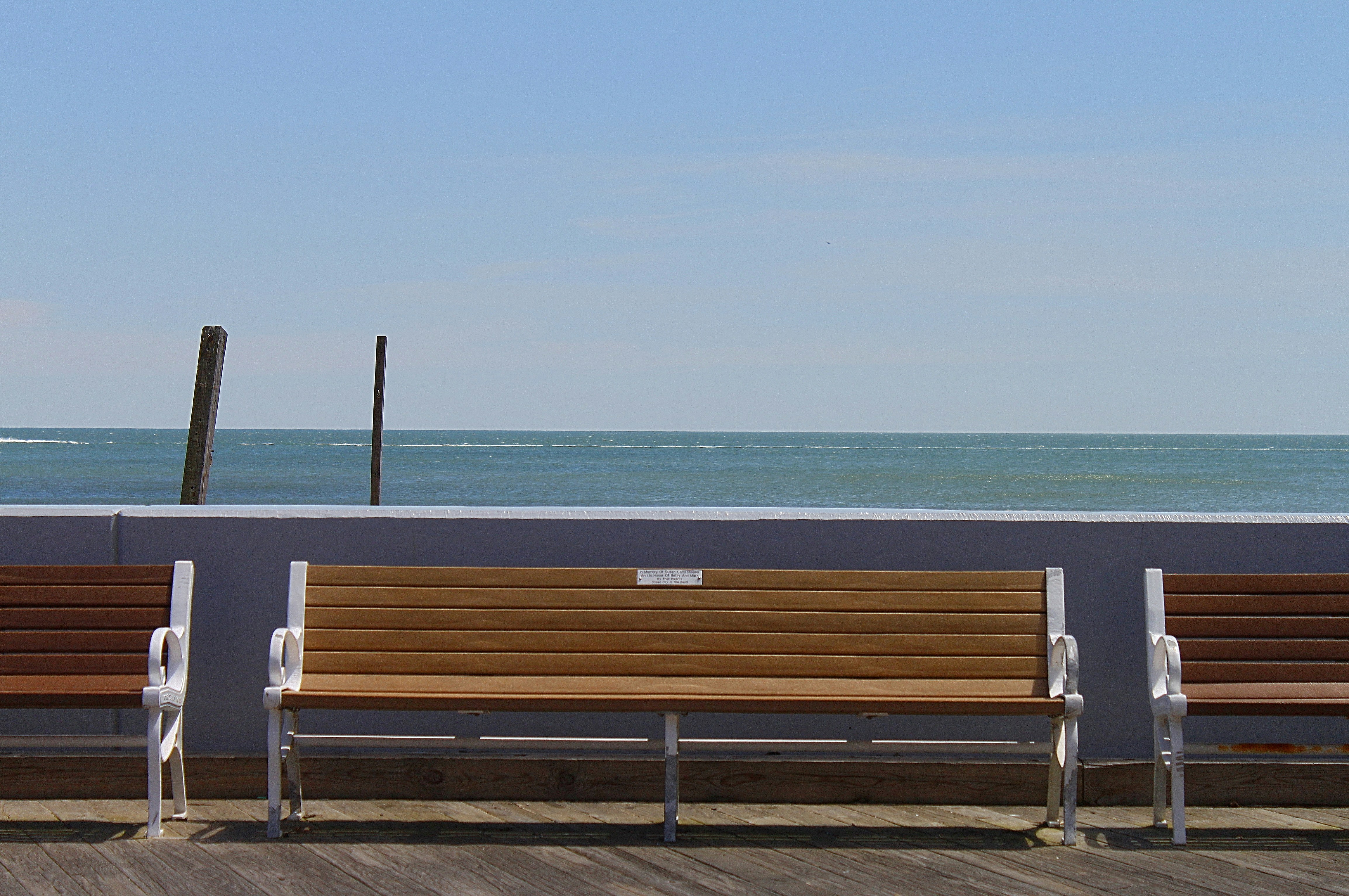 A row of wooden benches sitting on top of a pier