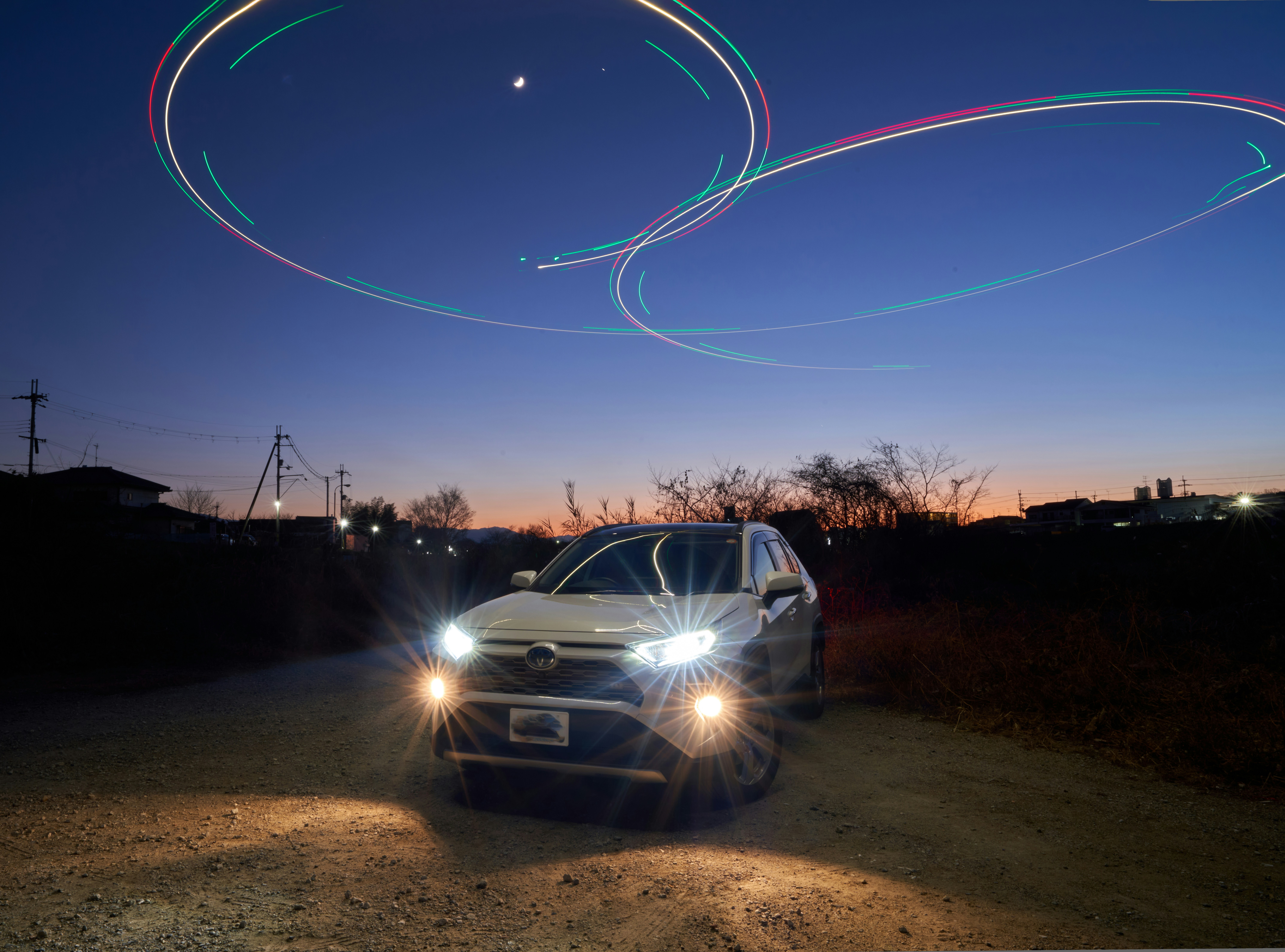 A car driving down a dirt road at night