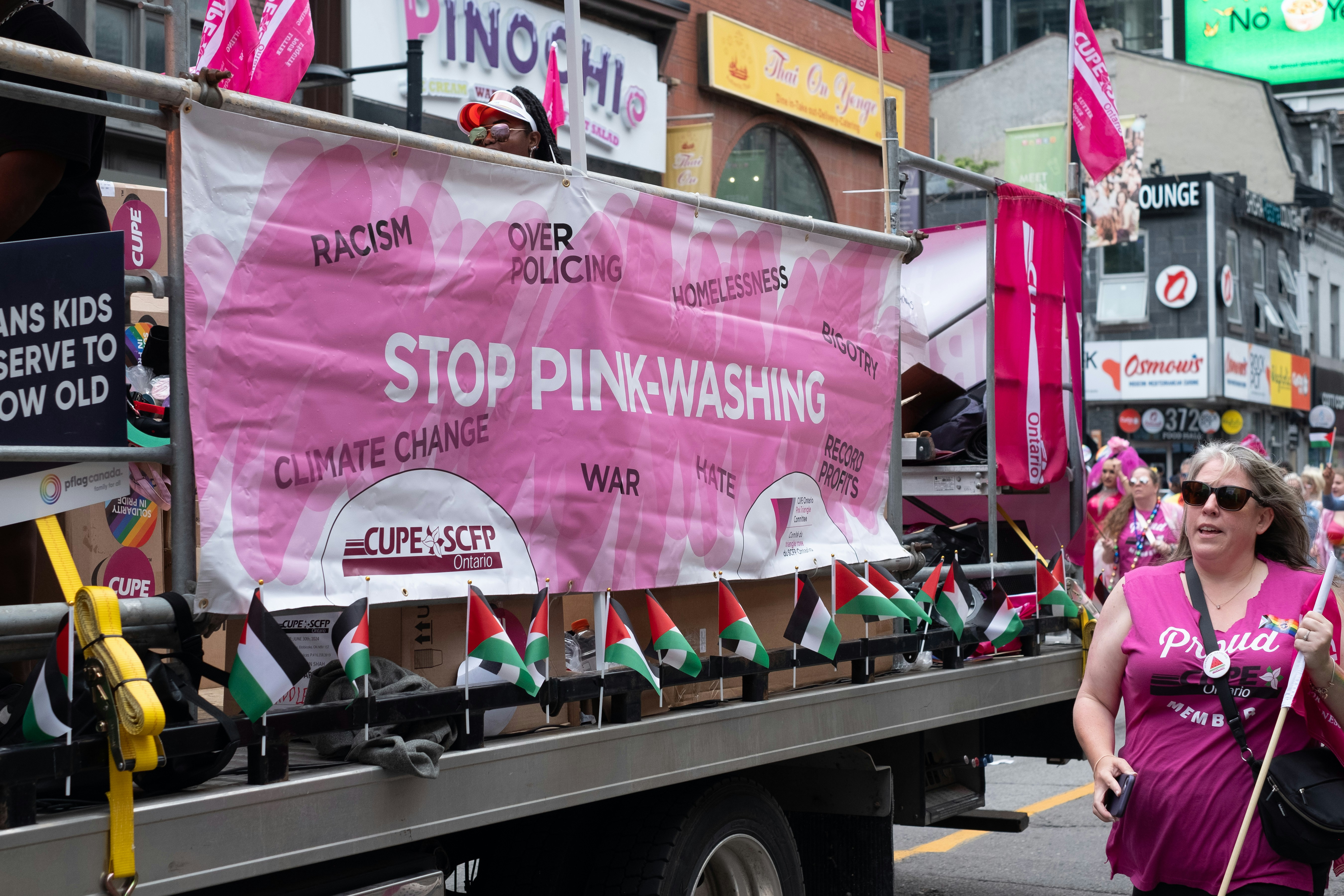 A woman in a pink shirt is walking down the street, Toronto Pride Parade 2024