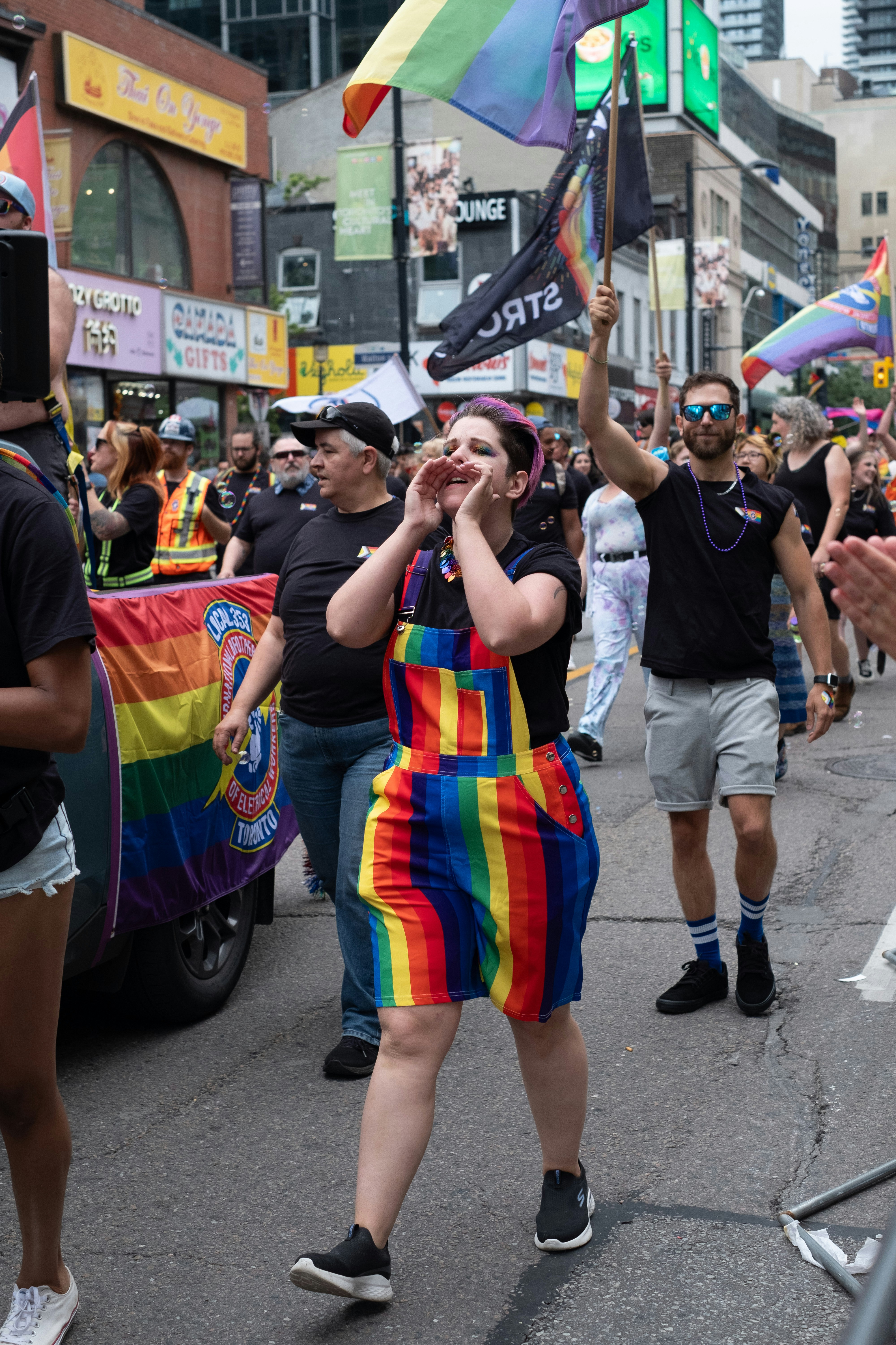 A group of people walking down a street holding flags