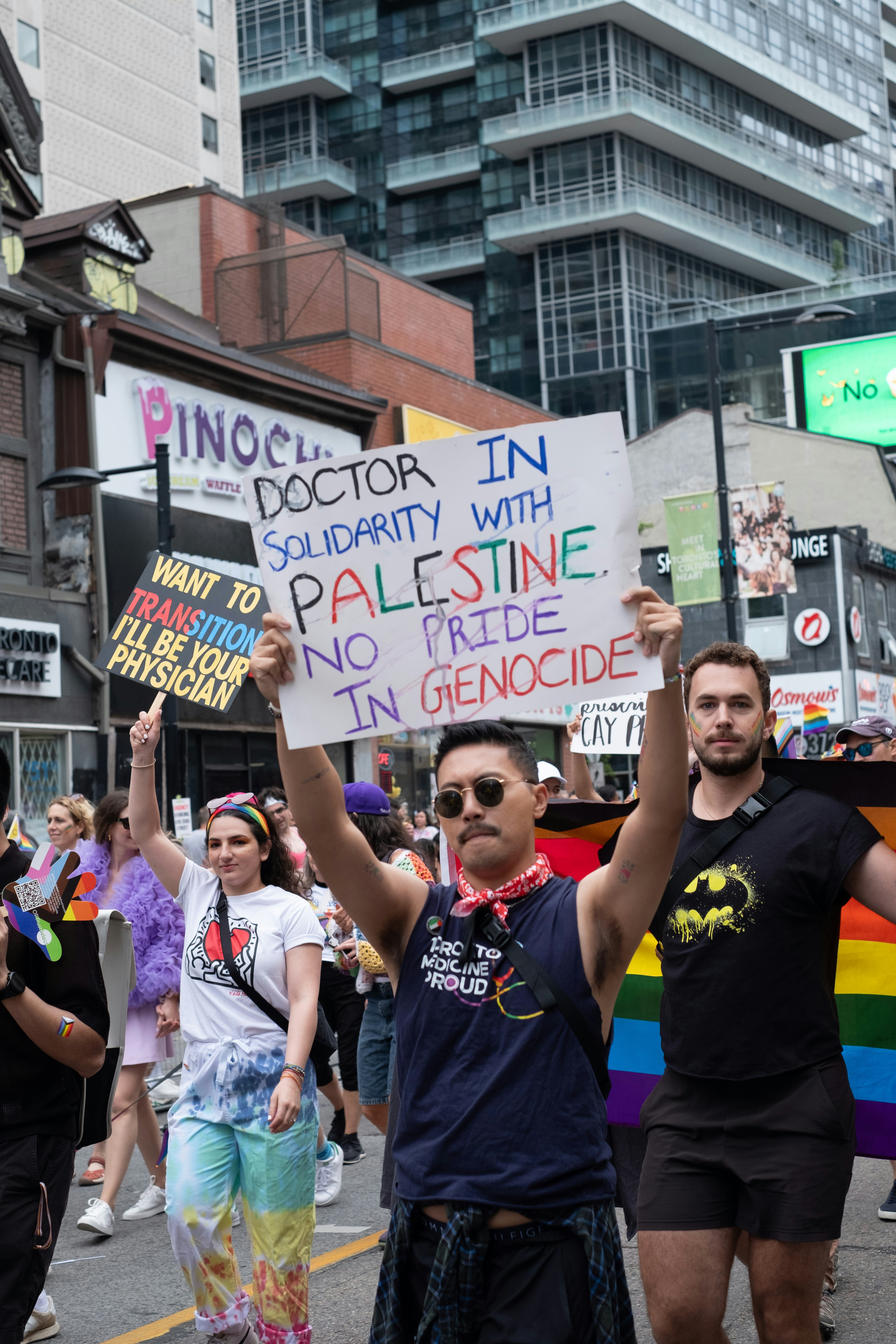 Eine Gruppe von Menschen marschiert eine Straße mit Schildern entlang