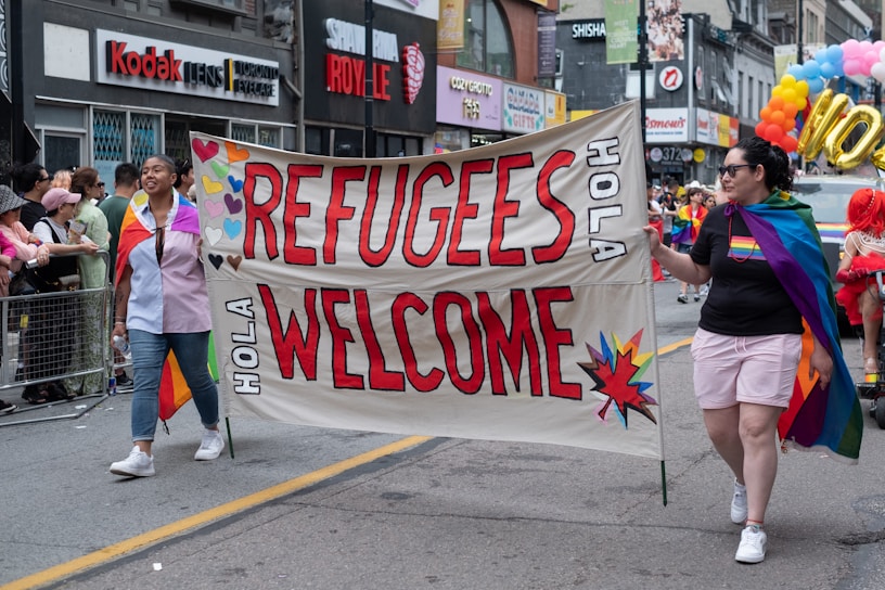 A group of people walking down a street holding a sign