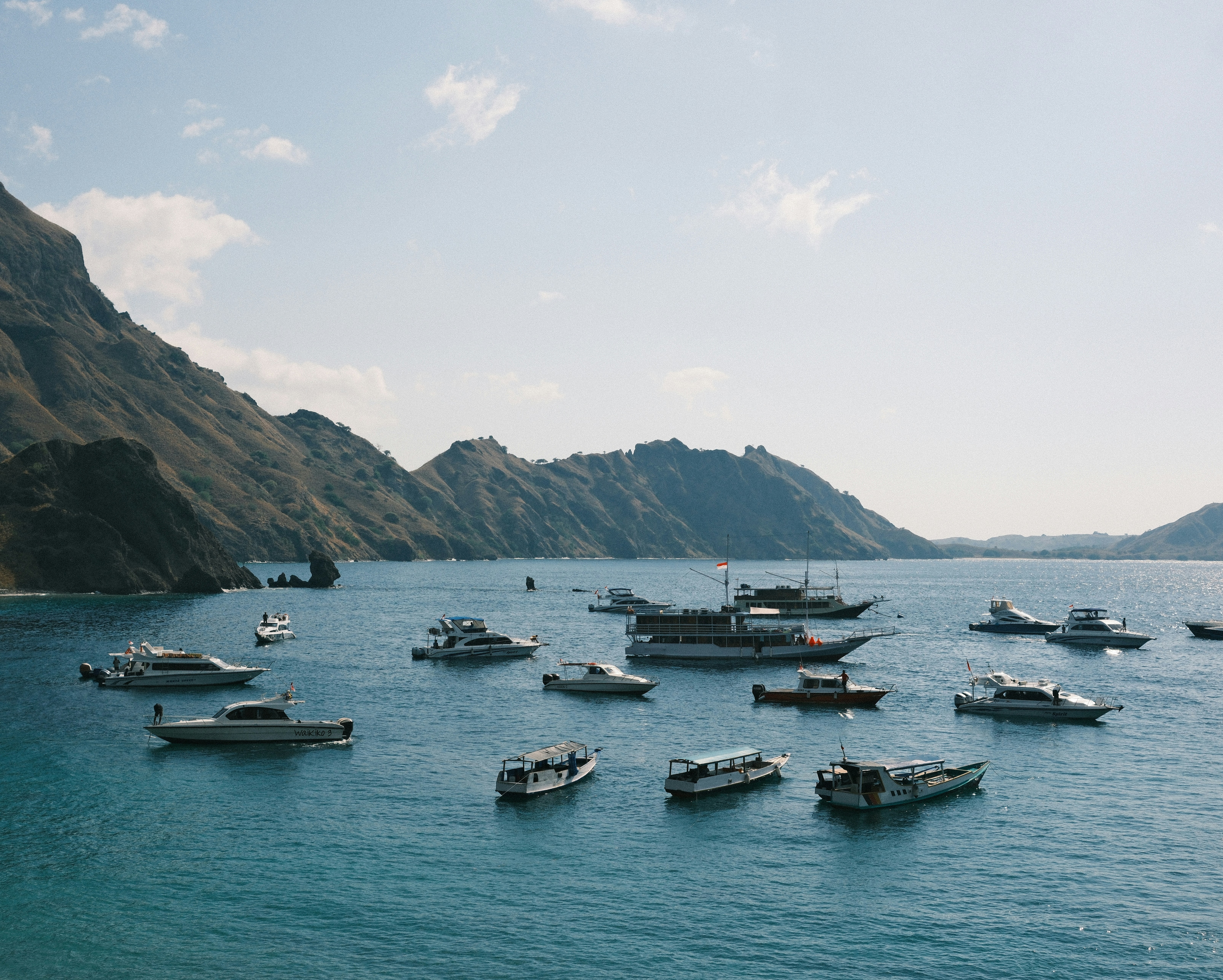 Un grupo de barcos flotando sobre una gran masa de agua