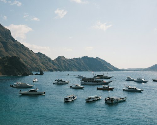 A group of boats floating on top of a large body of water — Komodo & Flores, Indonesia