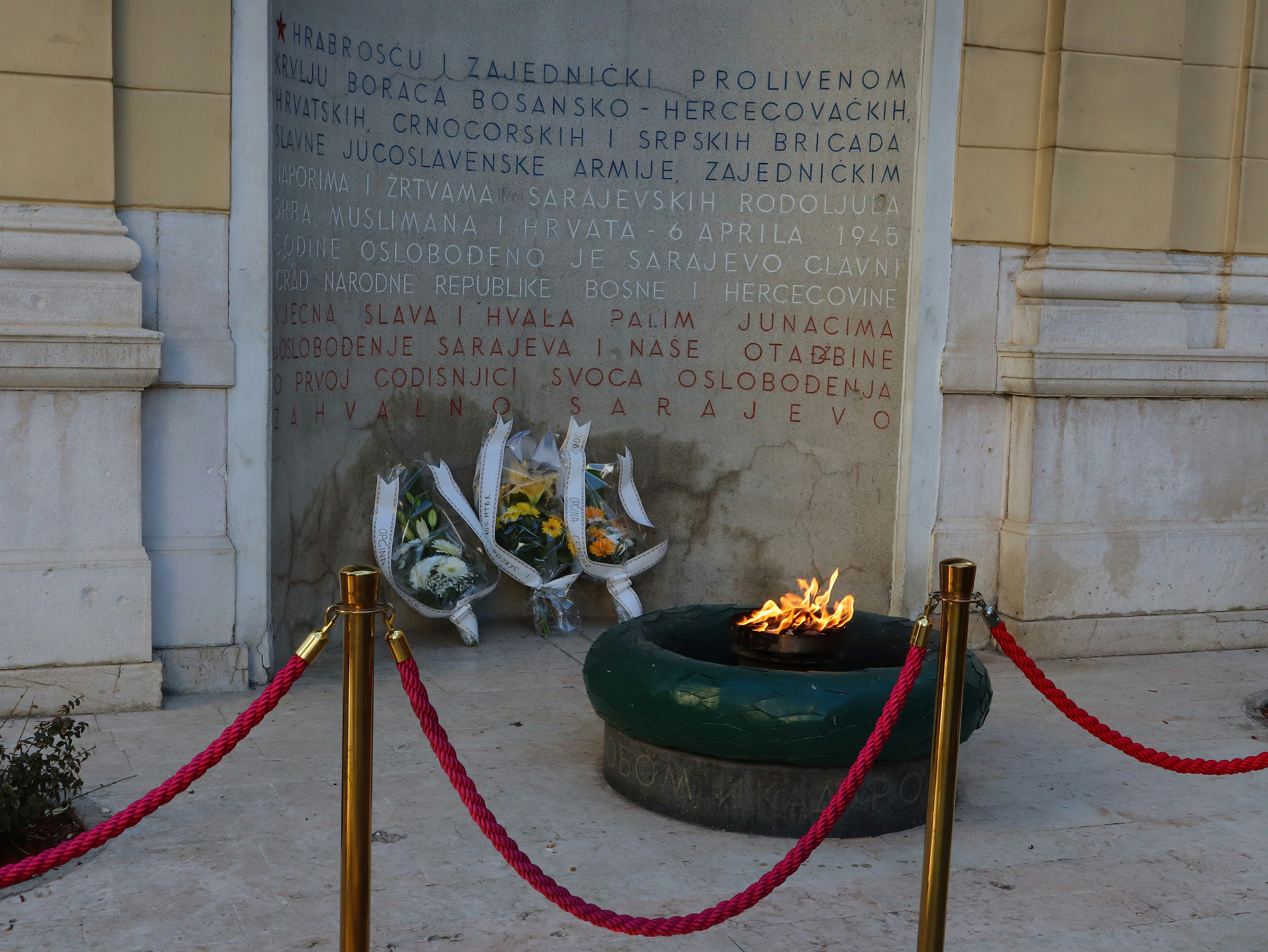 A fire pit in front of a building with a red rope