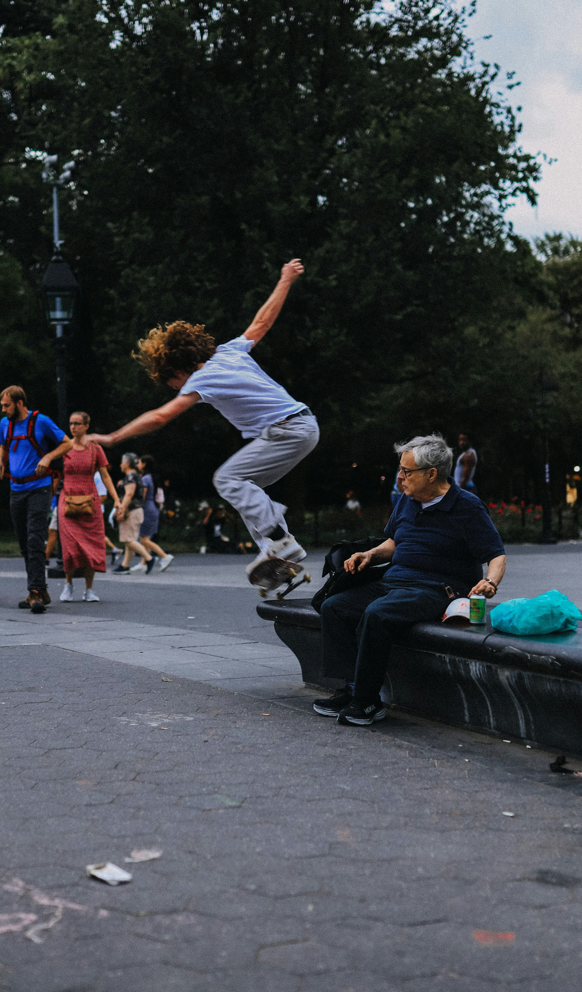 A man riding a skateboard up the side of a bench