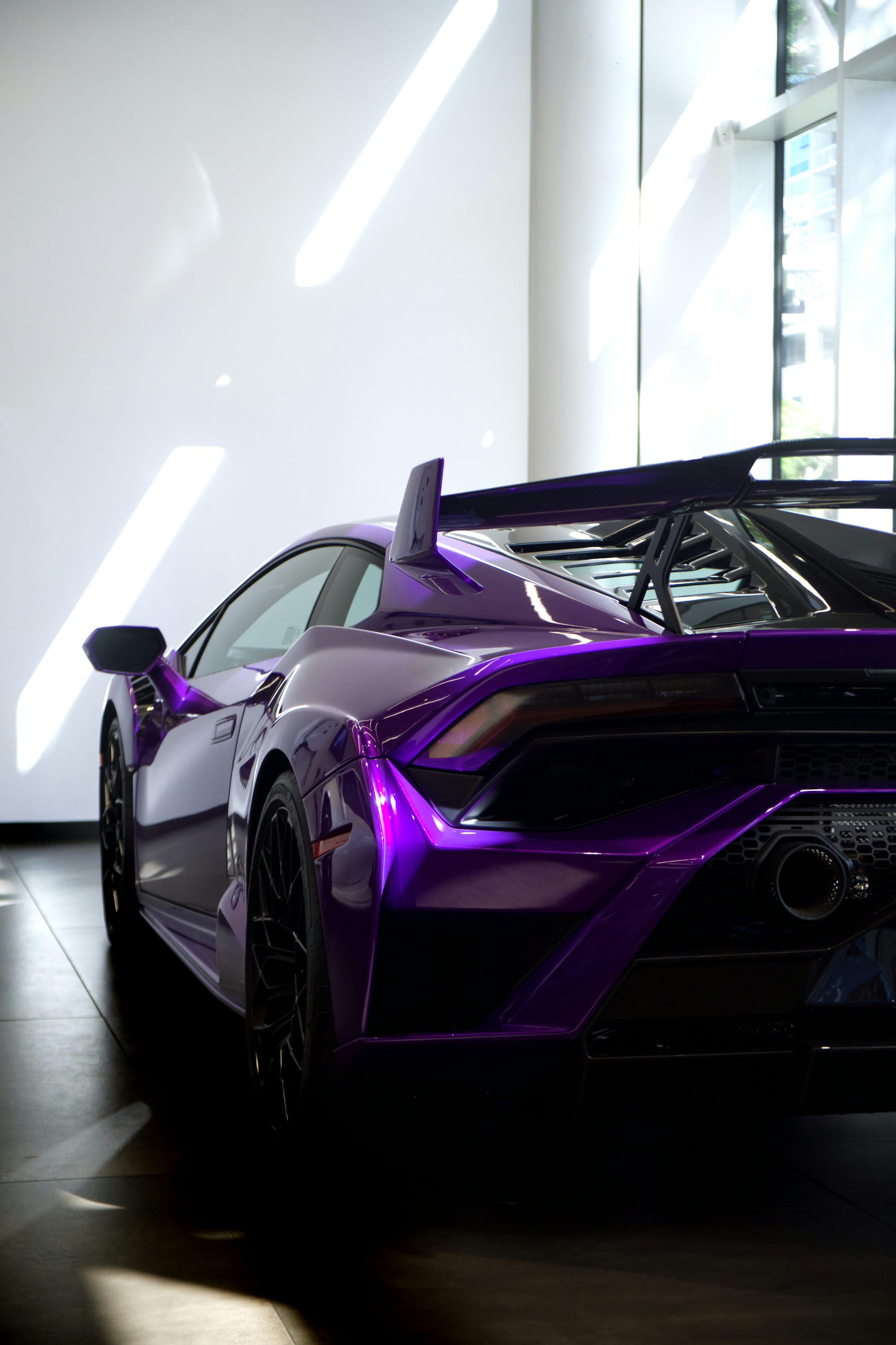 A purple sports car parked in front of a building