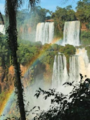 A waterfall with a rainbow in the middle of it