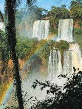 A waterfall with a rainbow in the middle of it