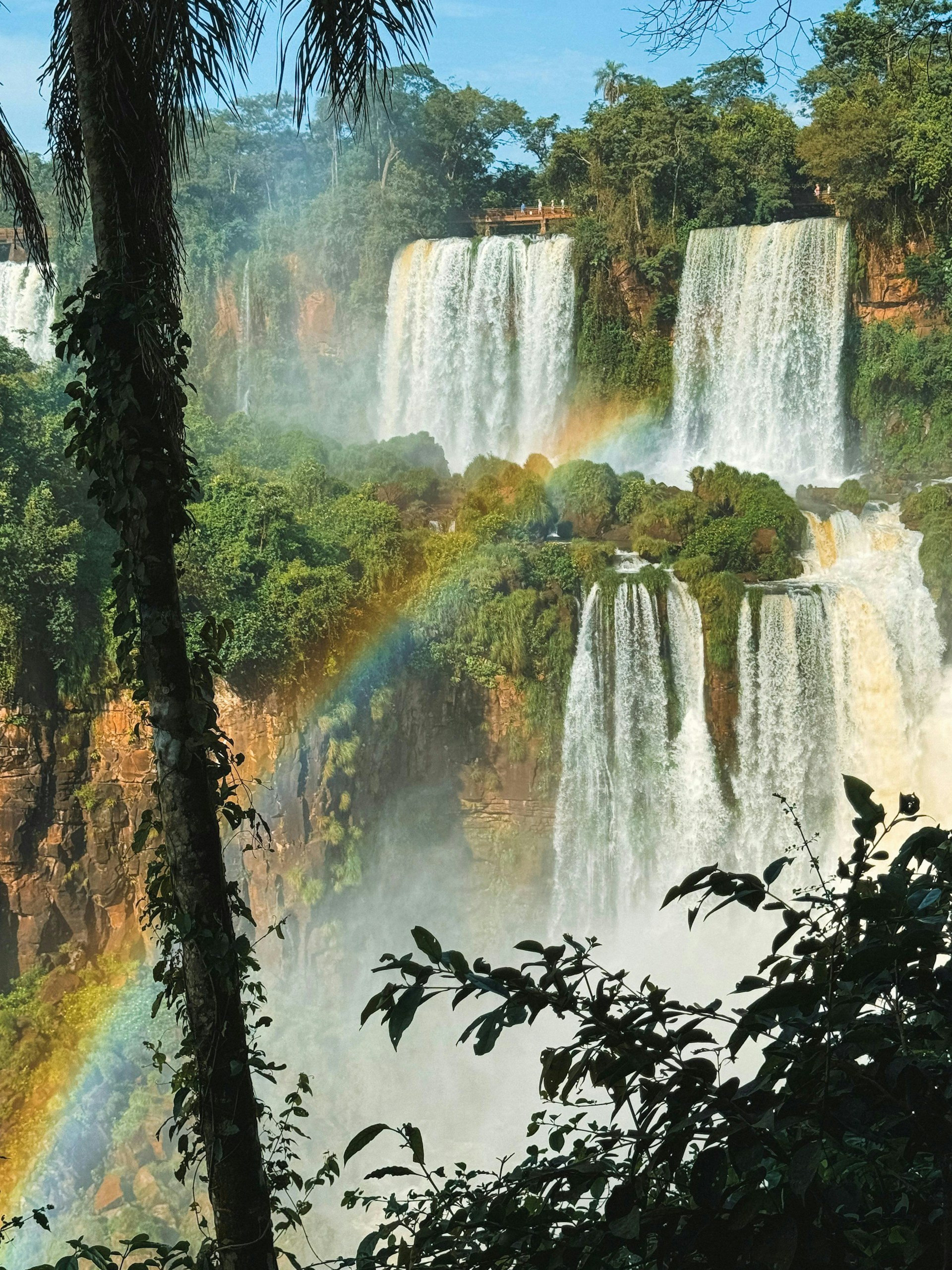 A waterfall with a rainbow in the middle of it