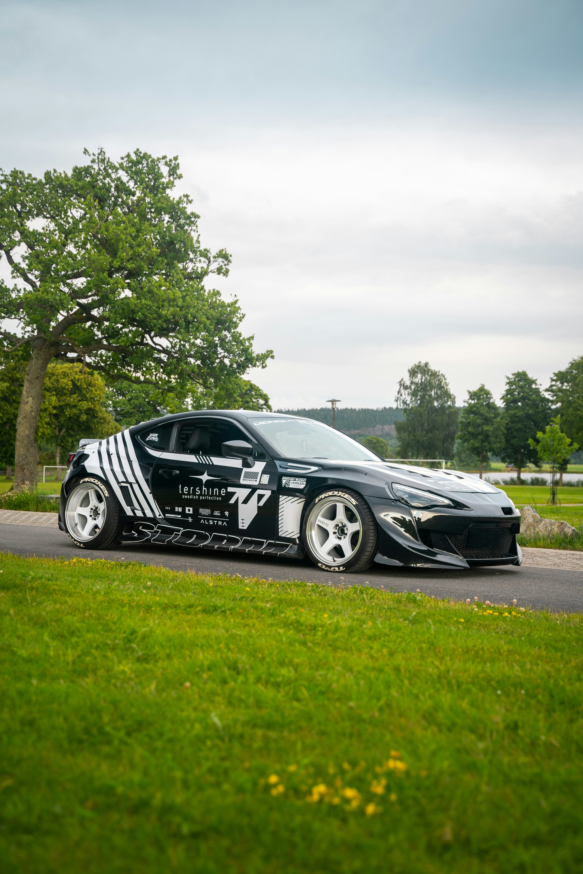 Ein schwarz-weißes Auto, das am Straßenrand geparkt ist