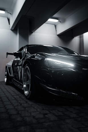 A black sports car parked in a parking garage