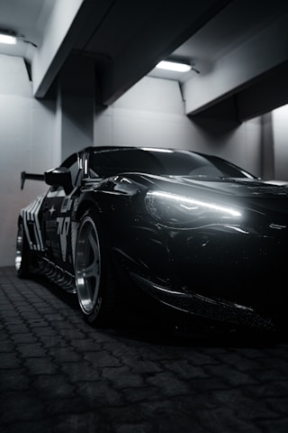 A black sports car parked in a parking garage