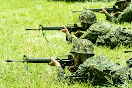 A group of soldiers with guns in the grass