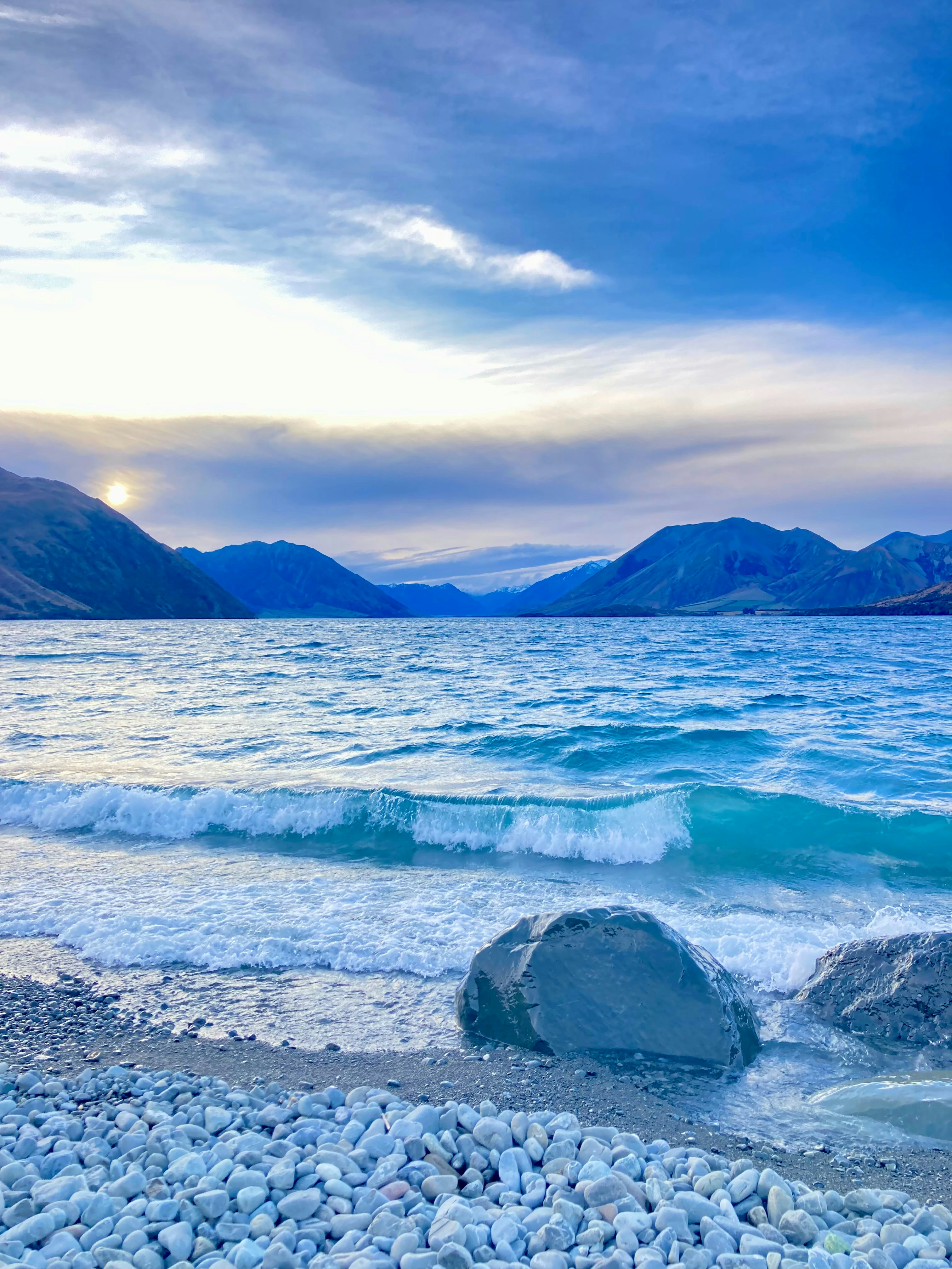 A rocky beach with a large rock in the foreground